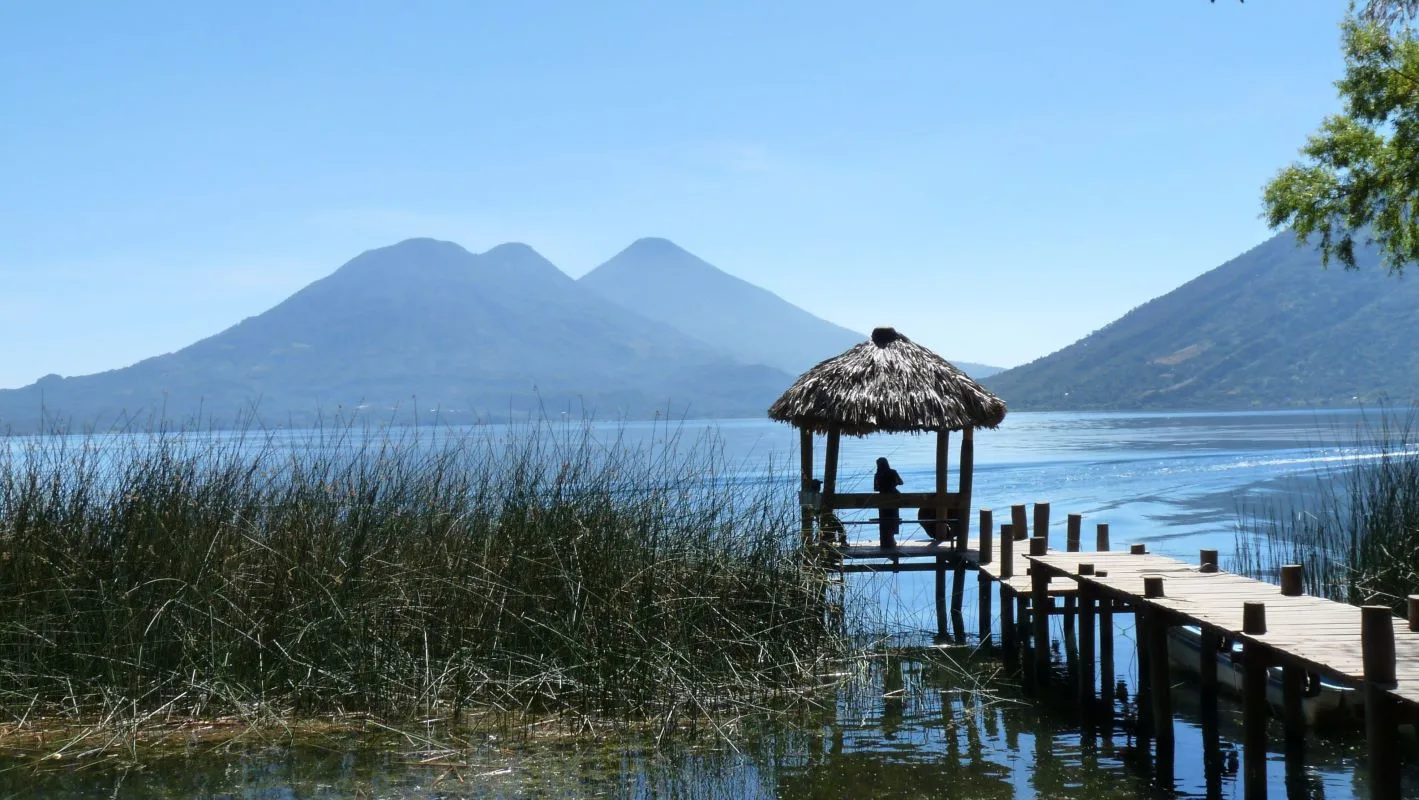 Atitlán-See mit Vulkanen und Holzsteg mit Strohdach, Guatemala Landschaft