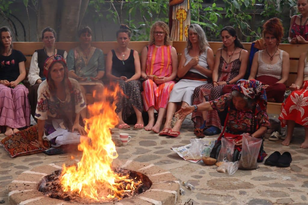 Frauengruppe um Lagerfeuer sitzend, weibliche Gemeinschaft und Ritual