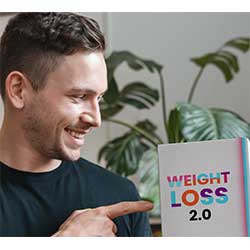 Mann in schwarzem Shirt hält Weight Loss 2.0 Box und lächelt