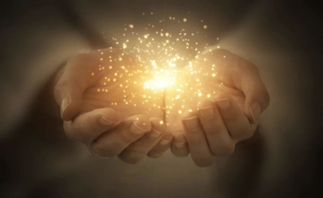 Abstrakte Grafik mit Händen, die goldenes Licht und Partikel halten, symbolisiert Energie und Erleuchtung