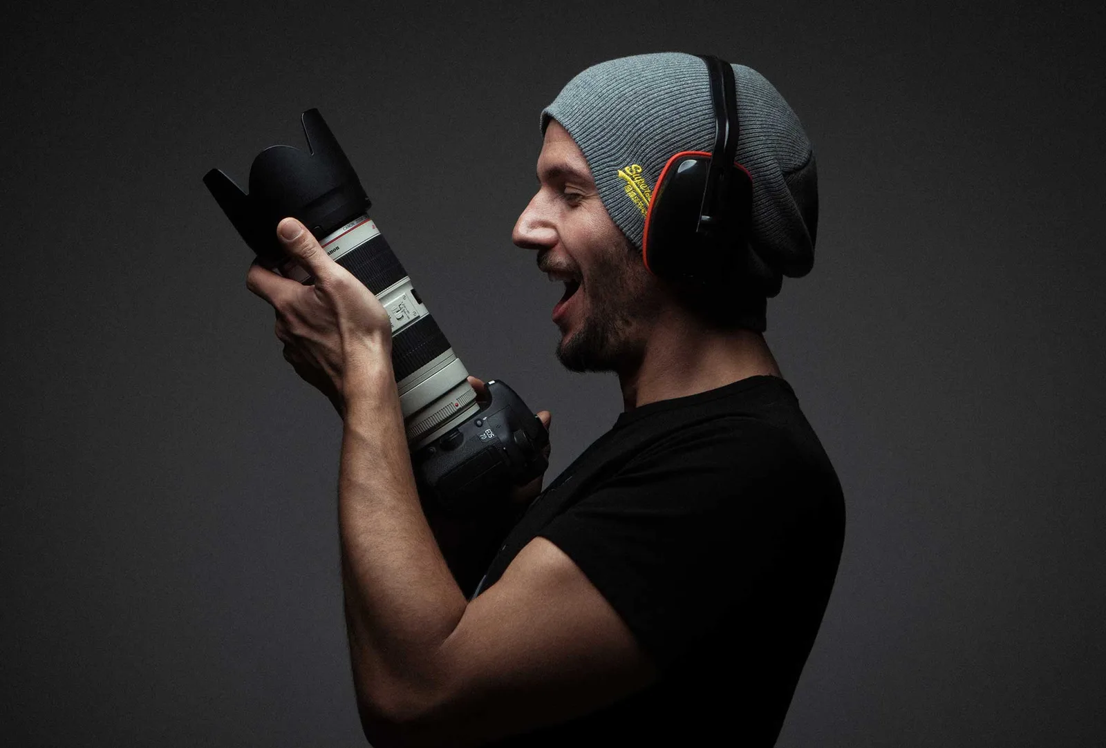 Enthusiastischer Fotograf mit Kamera und Headphones, Shootcamp Kursmotiv