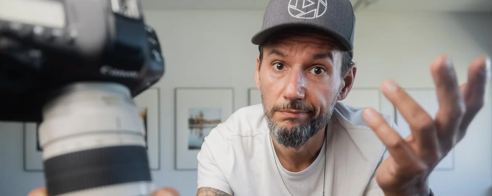 Mann mit Cap vor Kamera sprechend, Videostandbild Fotokurs
