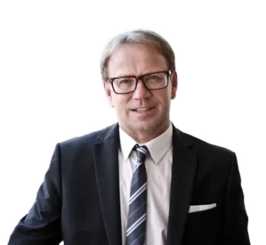 Porträtfoto von Erwin Huber, mittelalter Mann mit Brille in dunklem Anzug und Krawatte