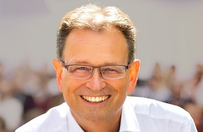 Porträt von Christian Rupp, Persönlichkeitstrainer und Coach, vor verschwommenem Publikum