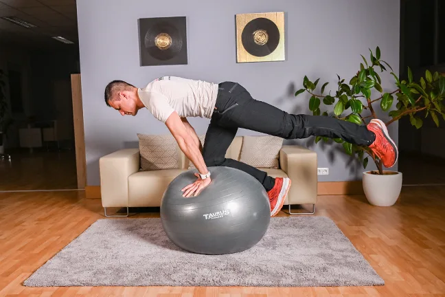 Mann in Plank-Position auf Gymnastikball, Gleichgewichtstraining