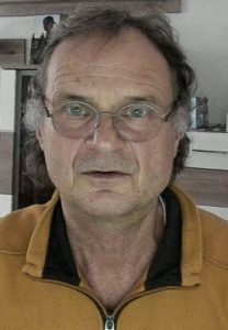 Porträt älterer Mann mit Brille und gelbem Pullover