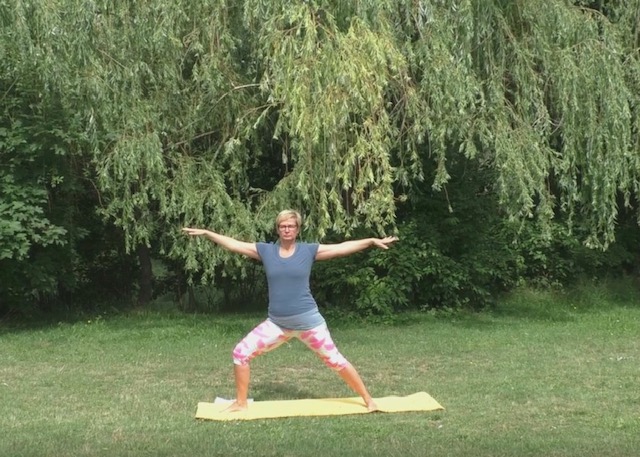 Yoga Live Online Kurs von Anke Schneider 8 Frau in Yoga-Pose auf Matte im Garten vor grünen Bäumen
