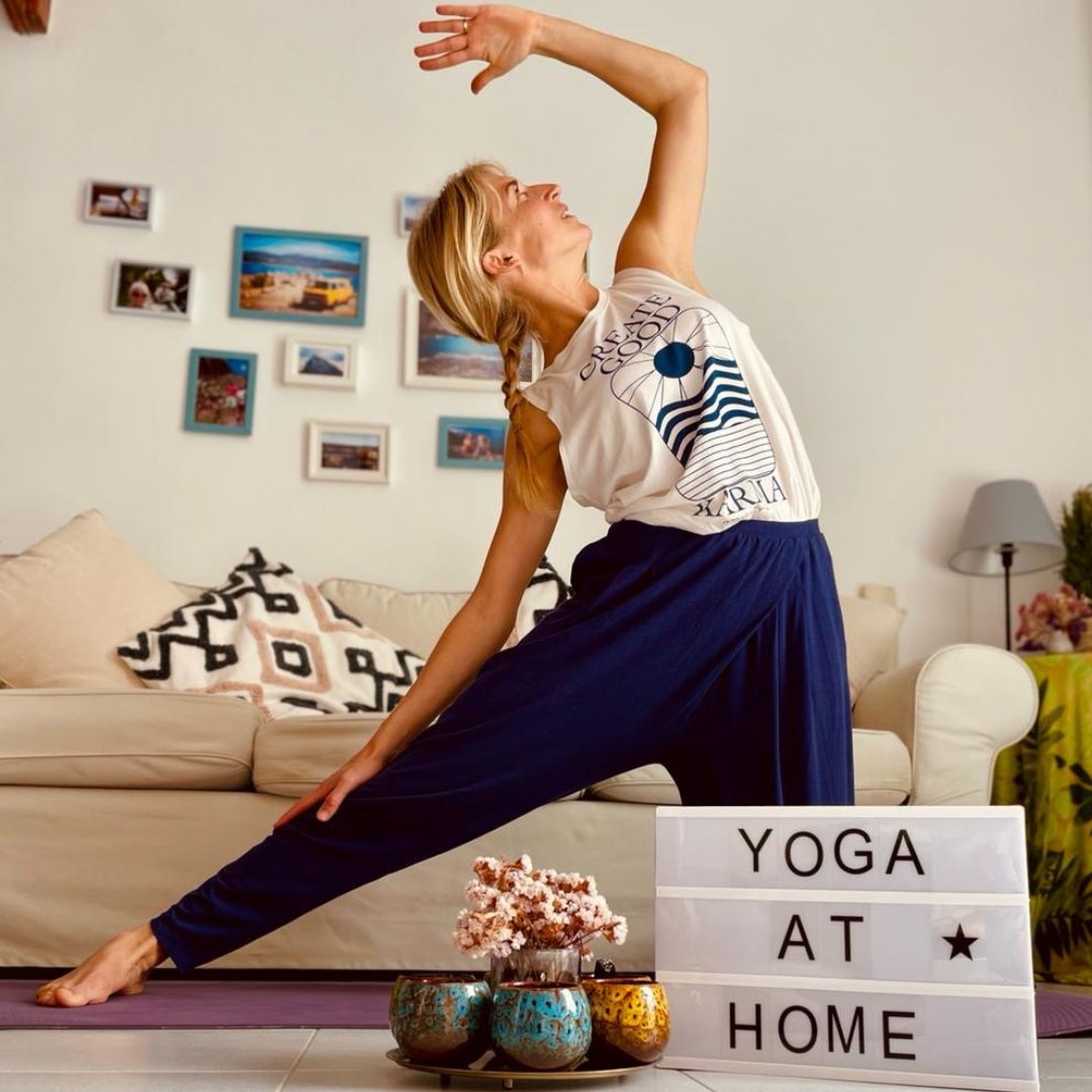Yoga Online Kurs mit Eva – Frau in weißem Top führt Yoga-Pose auf Matte auf