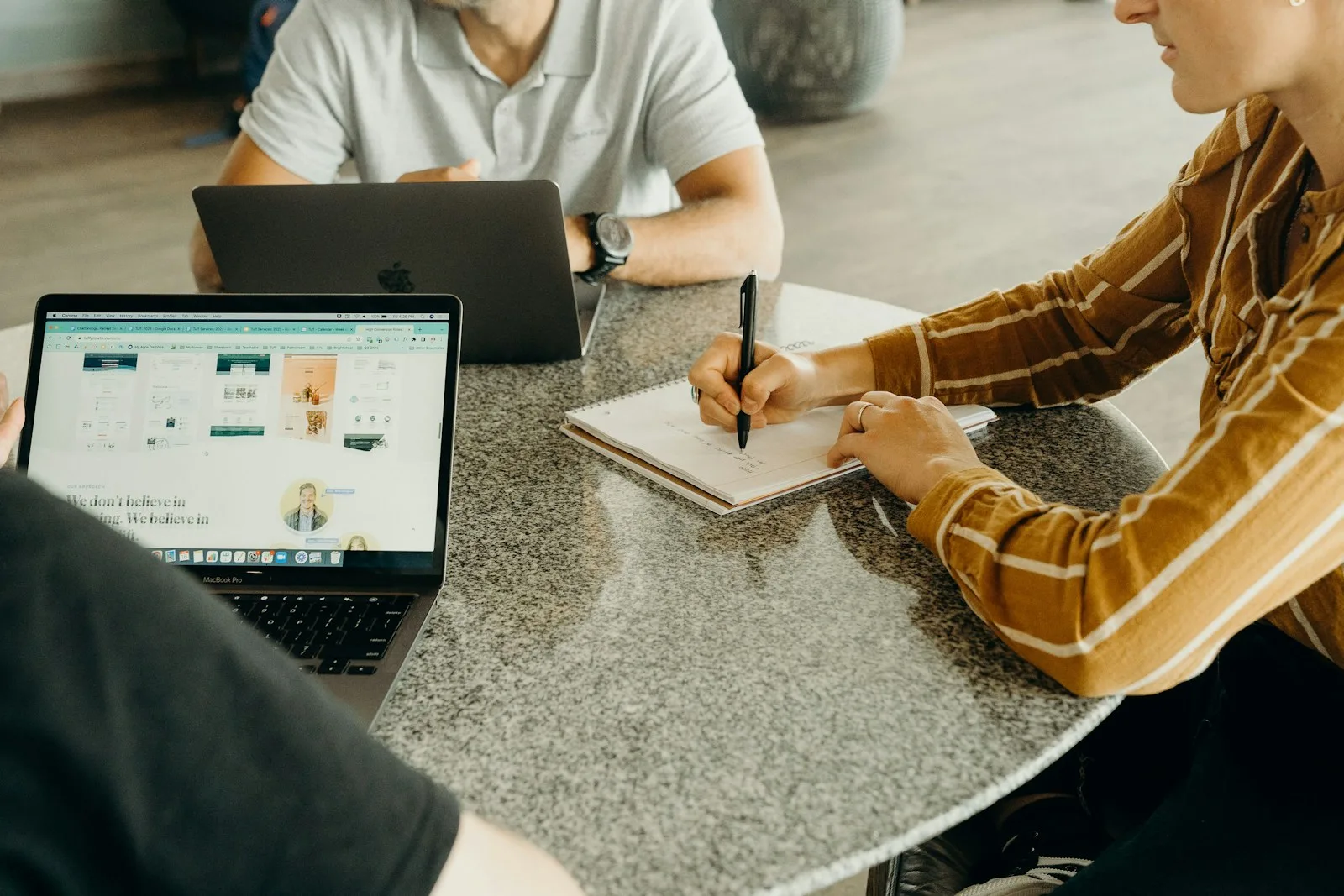Team plant Affiliate-Marketing-Strategie mit Laptop, Tablet und Notizbuch