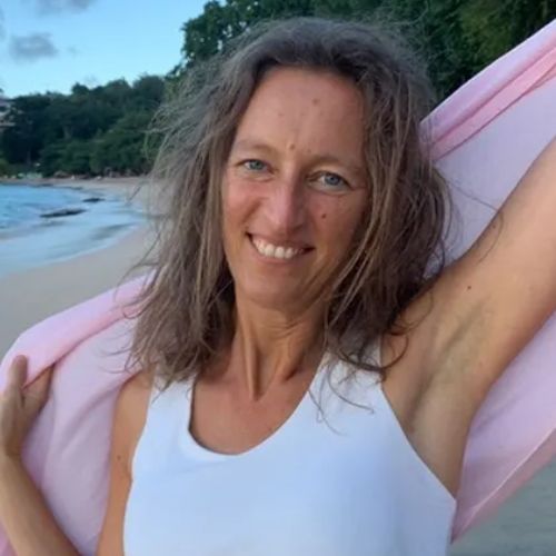 Porträtfoto von Cornelia Fach, Frau mit braunem Haar am Strand mit rosafarbenem Objekt