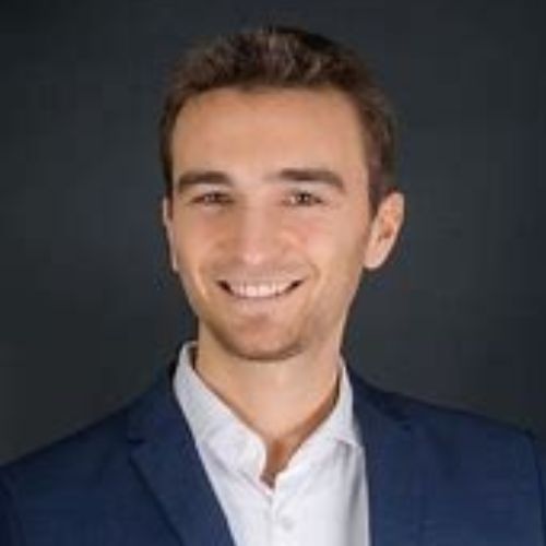 Porträtfoto von Ricardo Leppe, Mann mit dunklem Haar, dunklem Blazer vor grauem Hintergrund