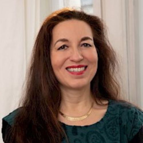 Porträt von Dr. Irene Promussas, Frau mit braunen Haaren und rotem Lippenstift
