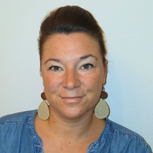 Cornelia Rauöcker, Frau mit braunen Haaren vor weißem Hintergrund, neutraler Ausdruck