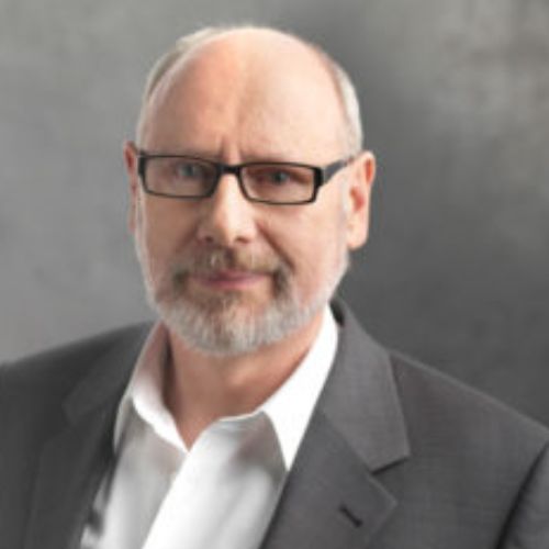 Prof. Dr. Günther Amann-Jennson, älterer Mann mit Brille und grauem Bart im dunklen Anzug