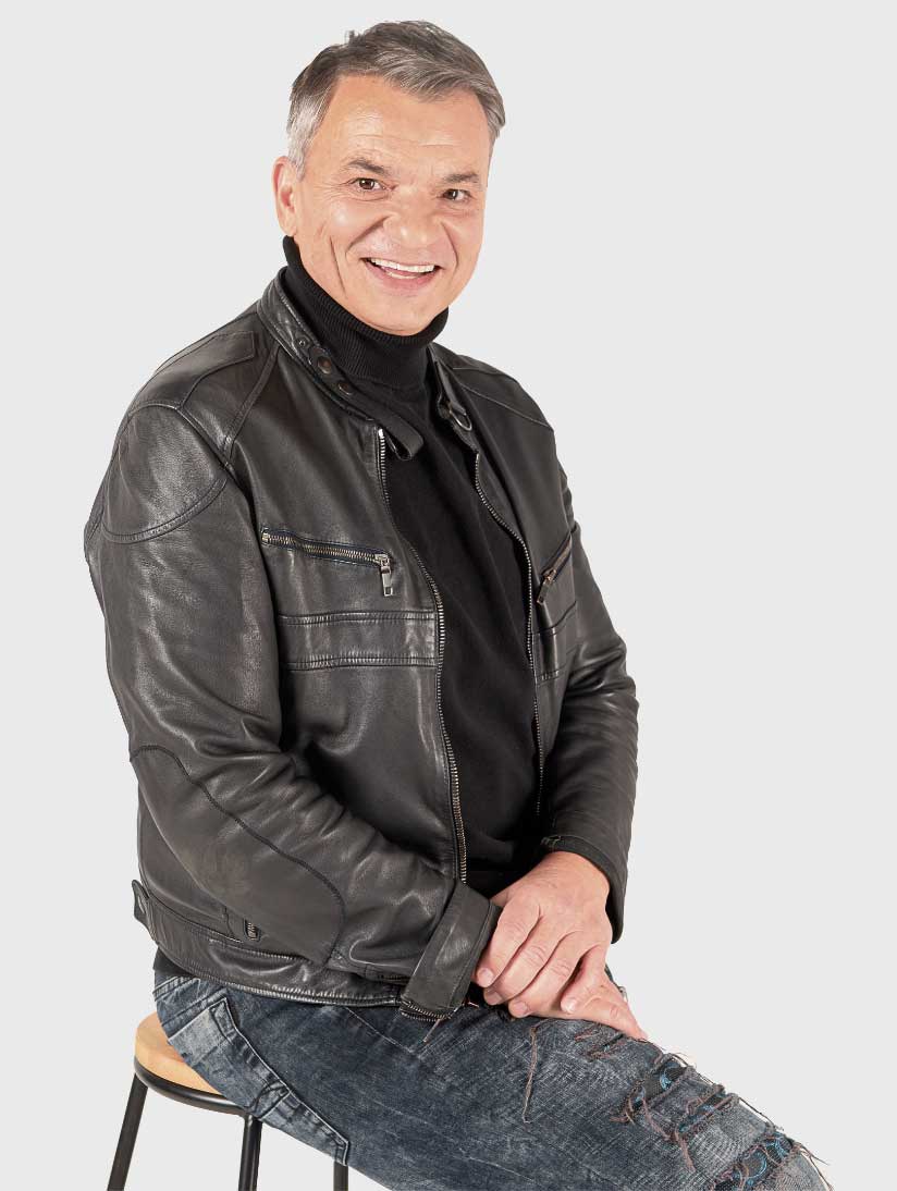 Portraitfoto eines Mannes mittleren Alters mit grauem Haar und schwarzer Lederjacke