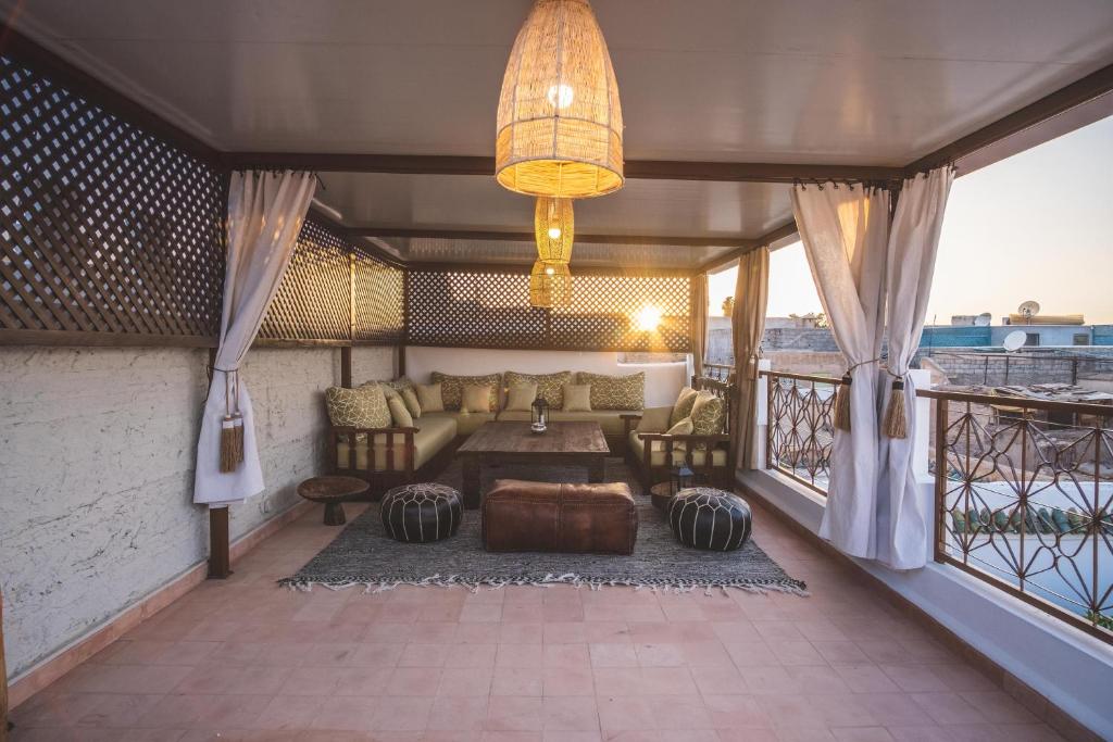 Terrasse mit Loungebereich bei Sonnenuntergang, Meerblick, beige Polstermöbel und goldene Hängeleuchten