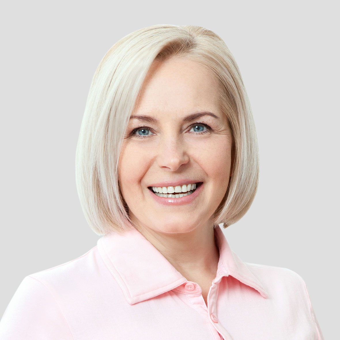 Portrait einer lächelnden Frau mit blondem Haar in rosa Bluse
