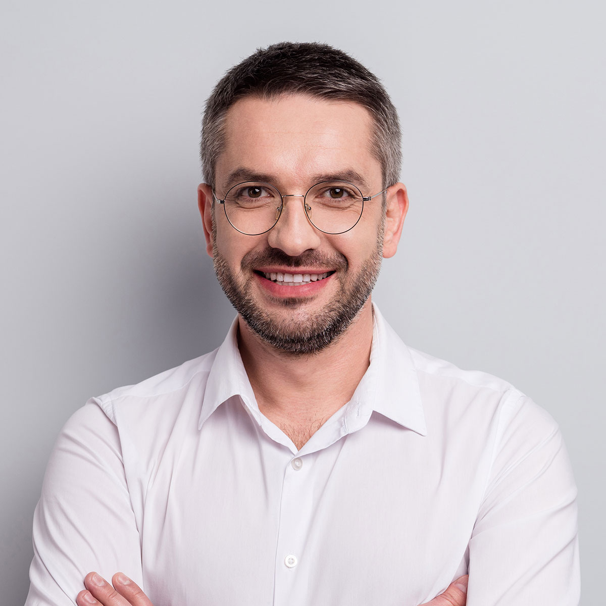 Portrait eines lächelnden Mannes mit Brille in weißem Hemd
