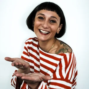 Julia Joanna Kwasniewska, Frau mit schwarzem Bob-Haarschnitt, rot-weiß gestreiftem Shirt, Tätowierung sichtbar