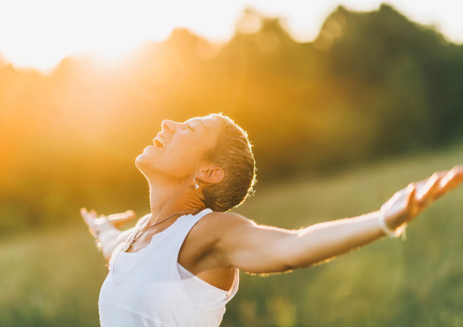 3-Stufen-Maximalenergie – Videokurs für mehr Energie 3 Frau mit ausgebreiteten Armen in Natur bei Sonnenaufgang, symbolisiert Energie und Vitalität