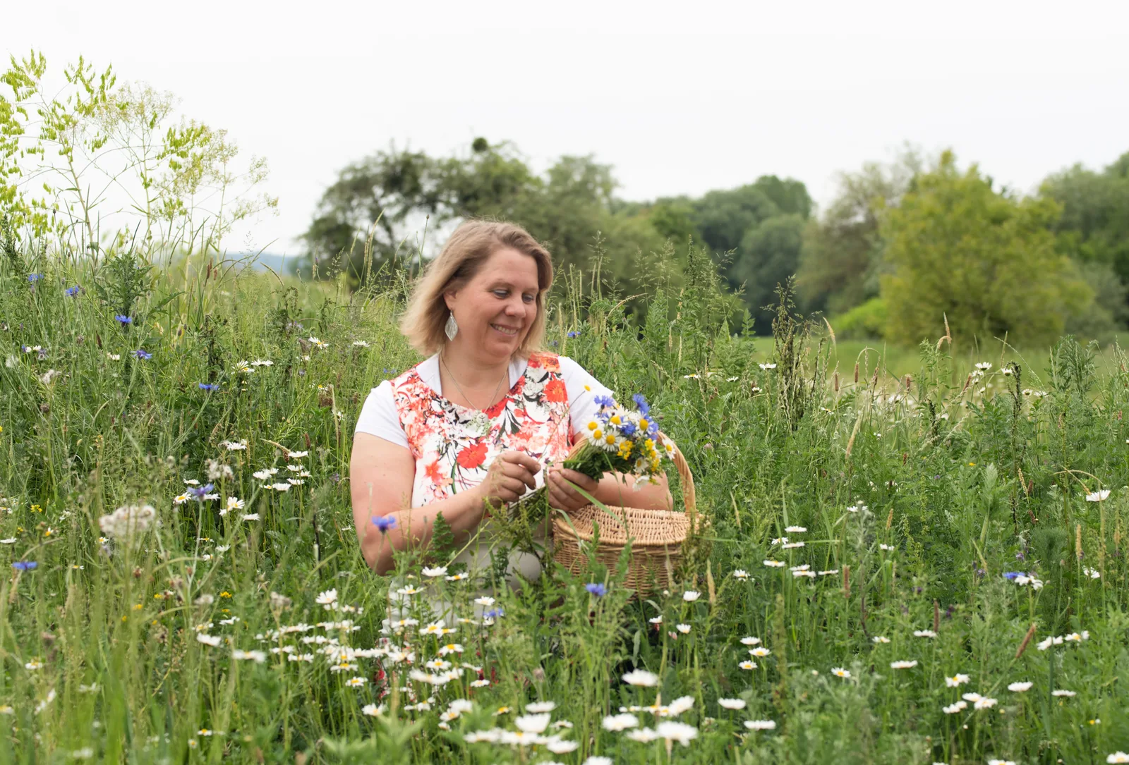 Heike Engel in Blütenwiese mit Korb voller Wildblumen