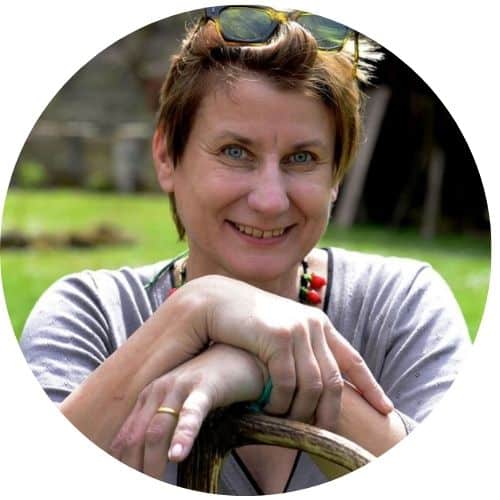 Gabriele Leonie Bräutigam, Frau mit braunem Haar und Sonnenbrille, hält Fisch, grüner Hintergrund
