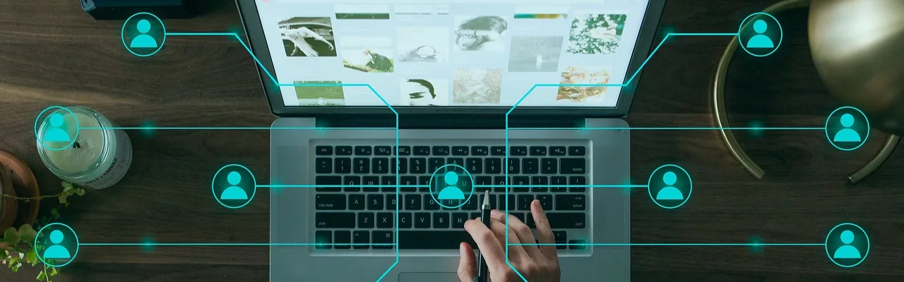 Laptop-Bildschirm mit Galerie-Interface und vernetzten Benutzer-Symbolen in Cyan, Hände auf Tastatur, Netzwerk-Verbindungen
