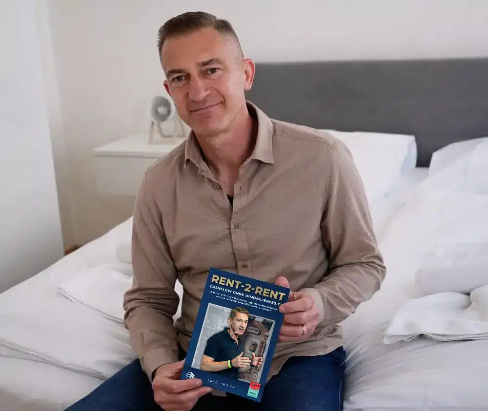 Eric Promm sitzt auf Bett und hält Rent-2-Rent Buch in den Händen