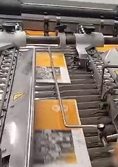 Videostandbild Druckerei zeigt Druckmaschine mit gelbem und grauem Papier