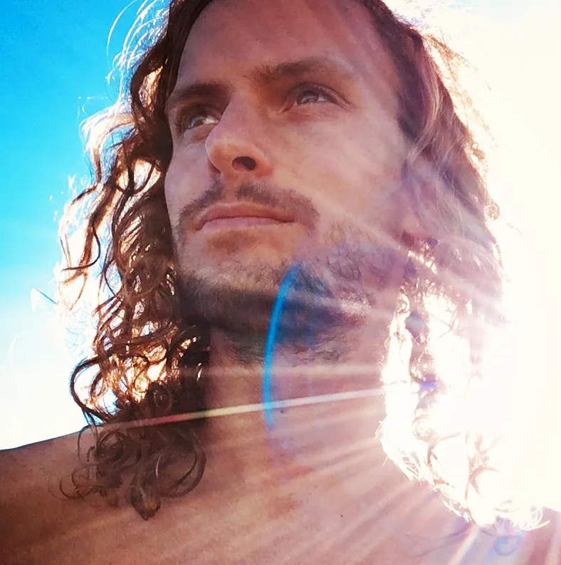 Portrait Mann mit langen braunen Locken, heller Lichtstrahlung, spirituelle Doppelbelichtung