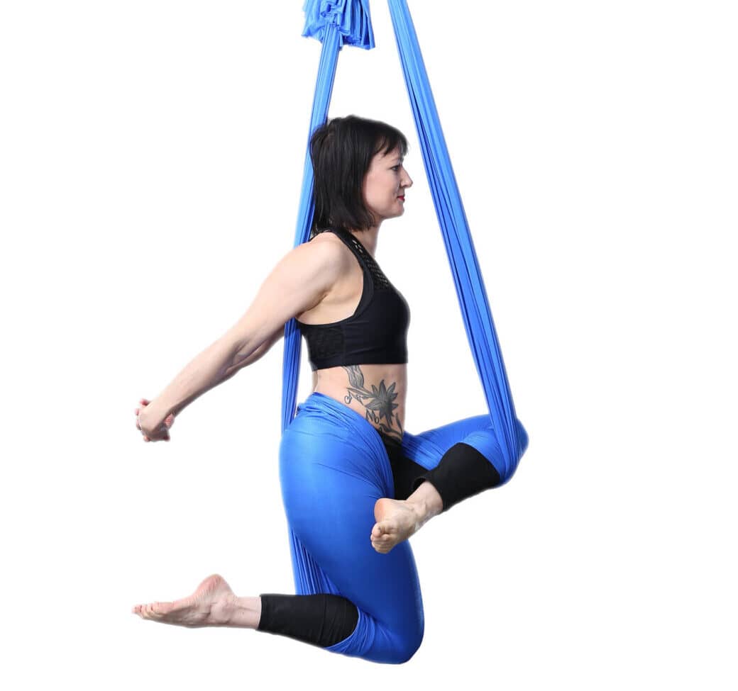 Aerial Yoga Performer in blauem Seidenschal mit Seitenflex