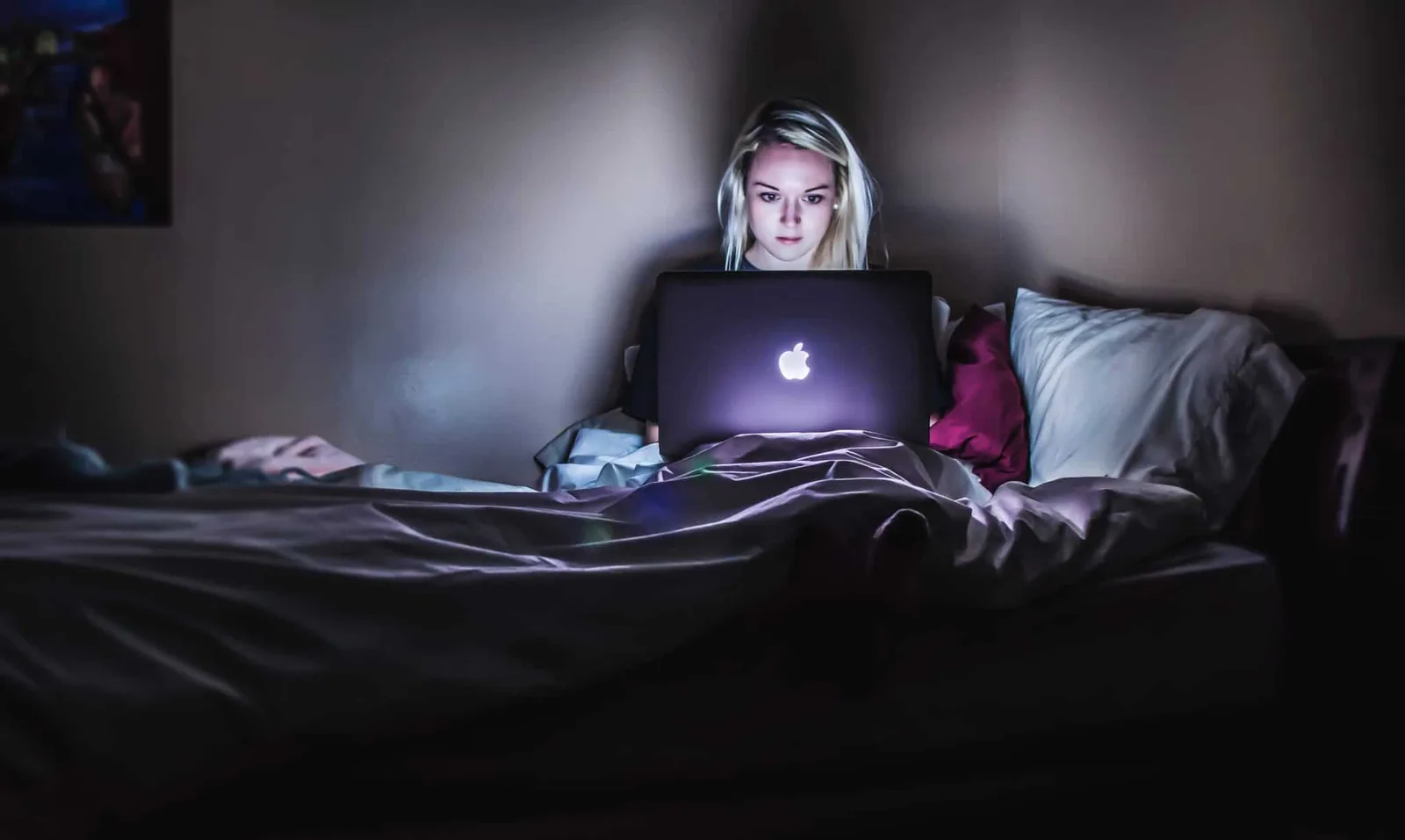 AGB Online-Shop Physische Produkte B2C von Dr. Ronald Kandelhard 5 Frau mit Laptop im Bett, blauer Bildschirm nachts, digitale Tätigkeit