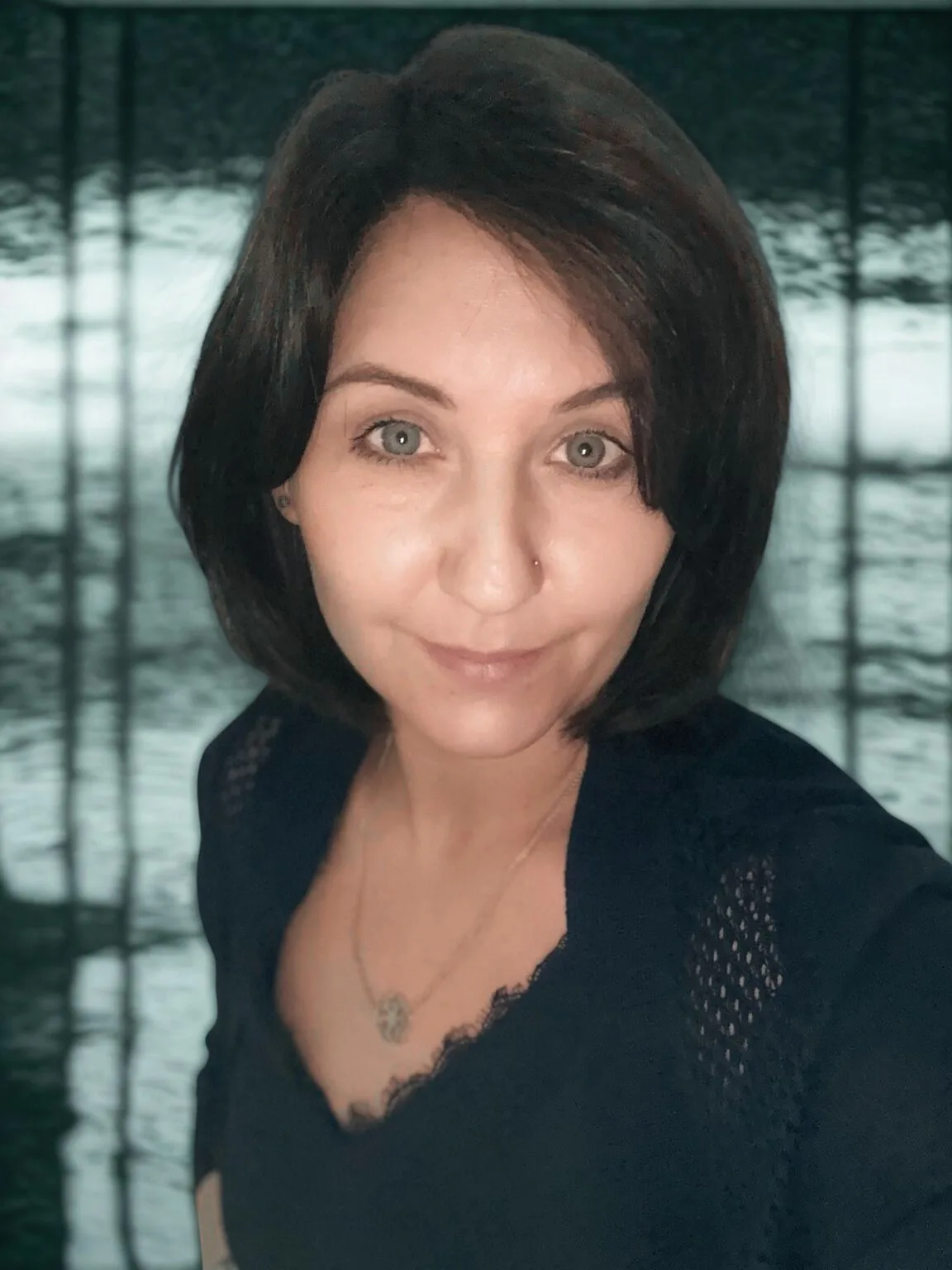 Selfie einer Frau mit dunklen Haaren nach Styling mit Spiegel
