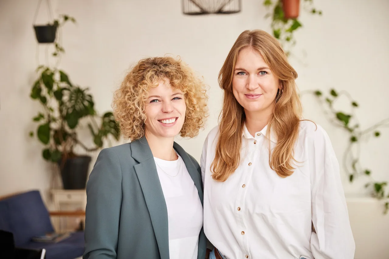 Anfänge aller Art Audiokurs gegen Stress von Friederike Reuver 8 Zwei Frauen in Business-Setting vor heller Wand mit Pflanzen