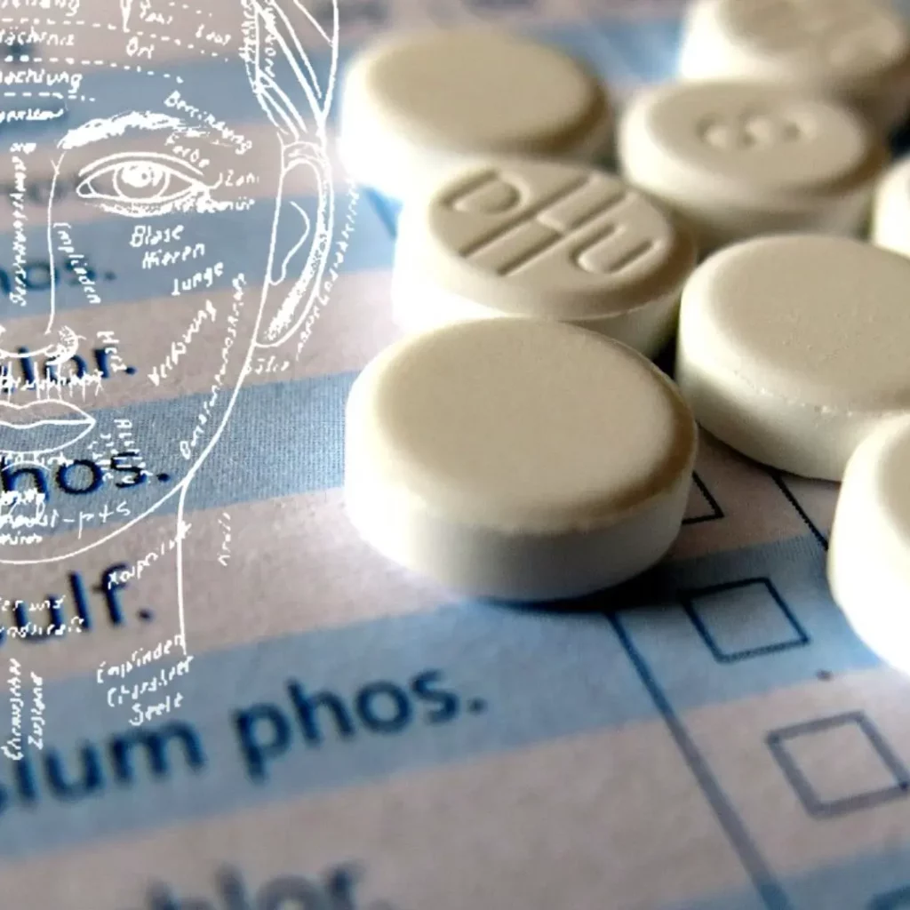 Schüsslersalz-Tabletten und Antlitz-Diagnose Grafik mit Stoff-Hintergrund