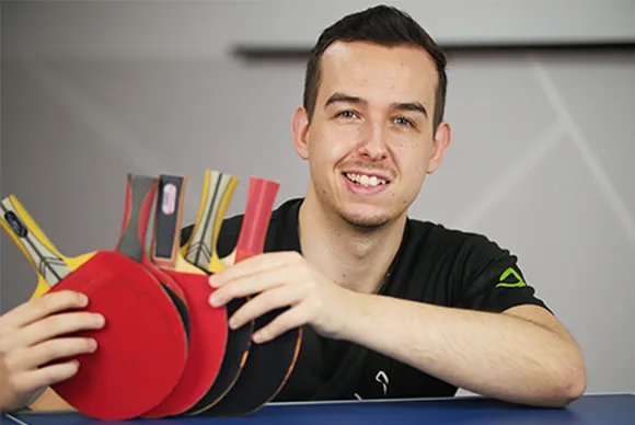 Tischtennisspieler Jannick hält mehrere Tischtennisschläger in den Händen