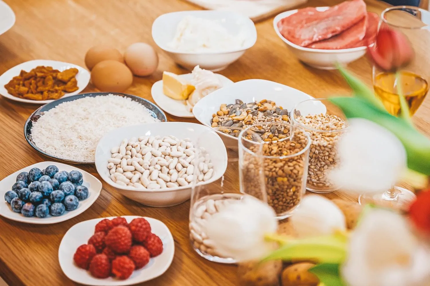 Ausbildung zum Hundeernährungsberater von Paulina Adamczyk 10 Verschiedene Lebensmittel arrangiert: Obst, Getreide, Fleisch, Eier auf Holz