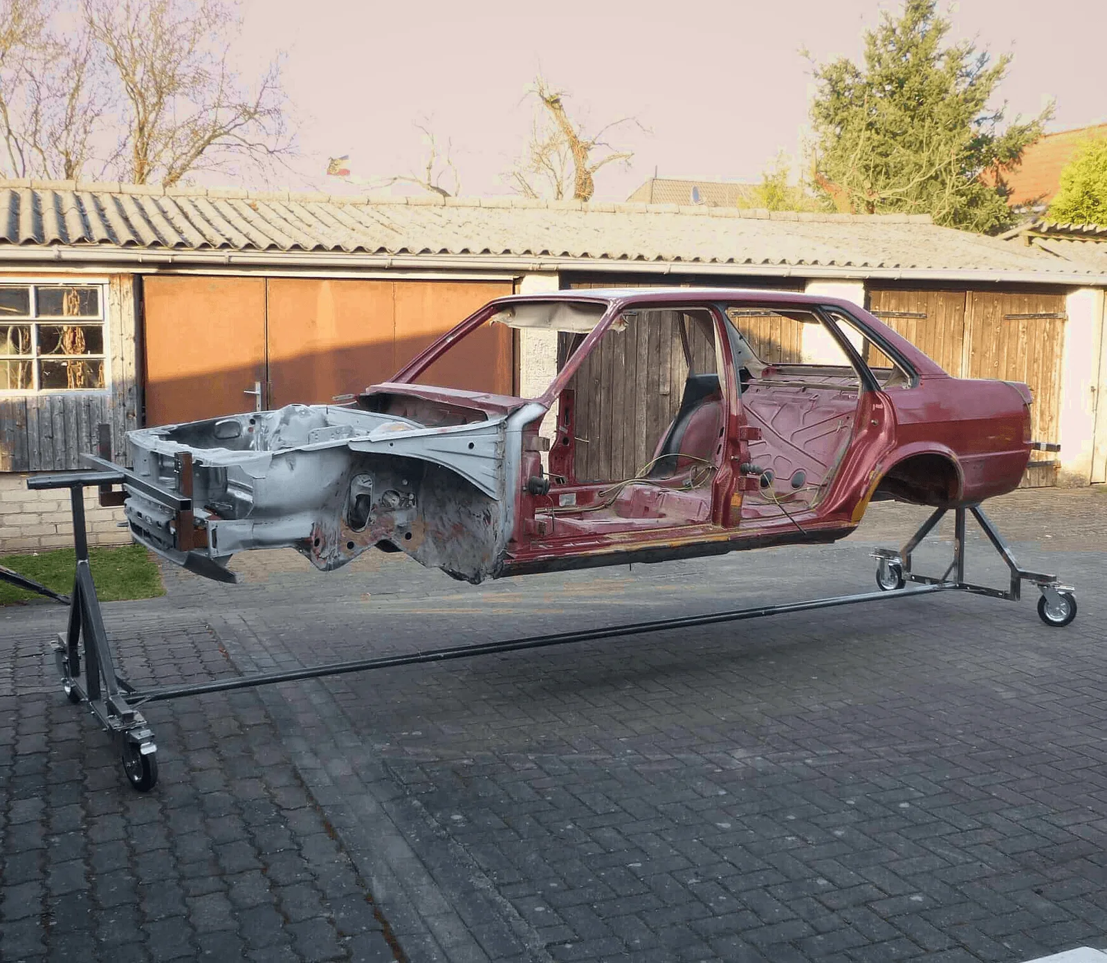 Zerlegter Audi 90 auf Auto Drehgestell in Werkstatt, Karosserie separat auf Ständer