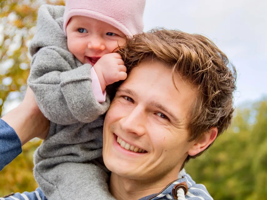 Babyhandling – Videokurs für Eltern von Pelle Wiedling 4 Vater hält lächelndes Baby auf der Schulter im Freien