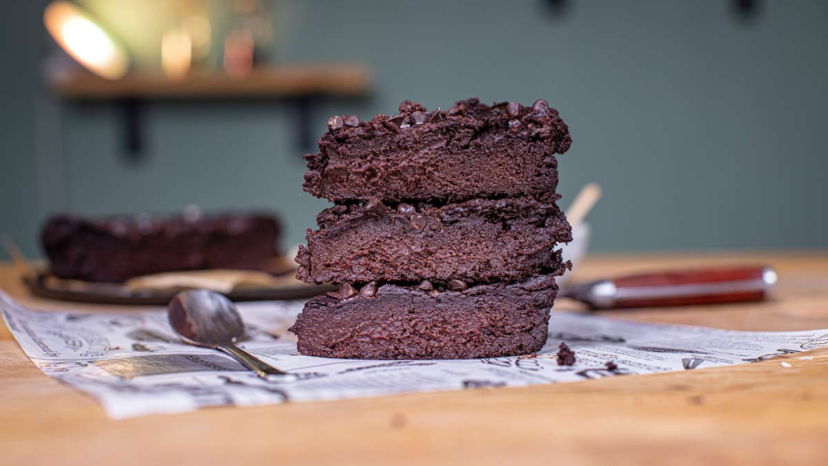 Drei gestapelte Brownies auf Papier mit Löffel und Beleuchtung, Nahaufnahme