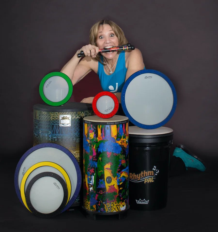 Bambini Beats Manual/Workbook mit Videos – Trommelanleitung Kita 8 Instruktorin mit verschiedenen farbigen Drums Alive Trommeln und Schläger