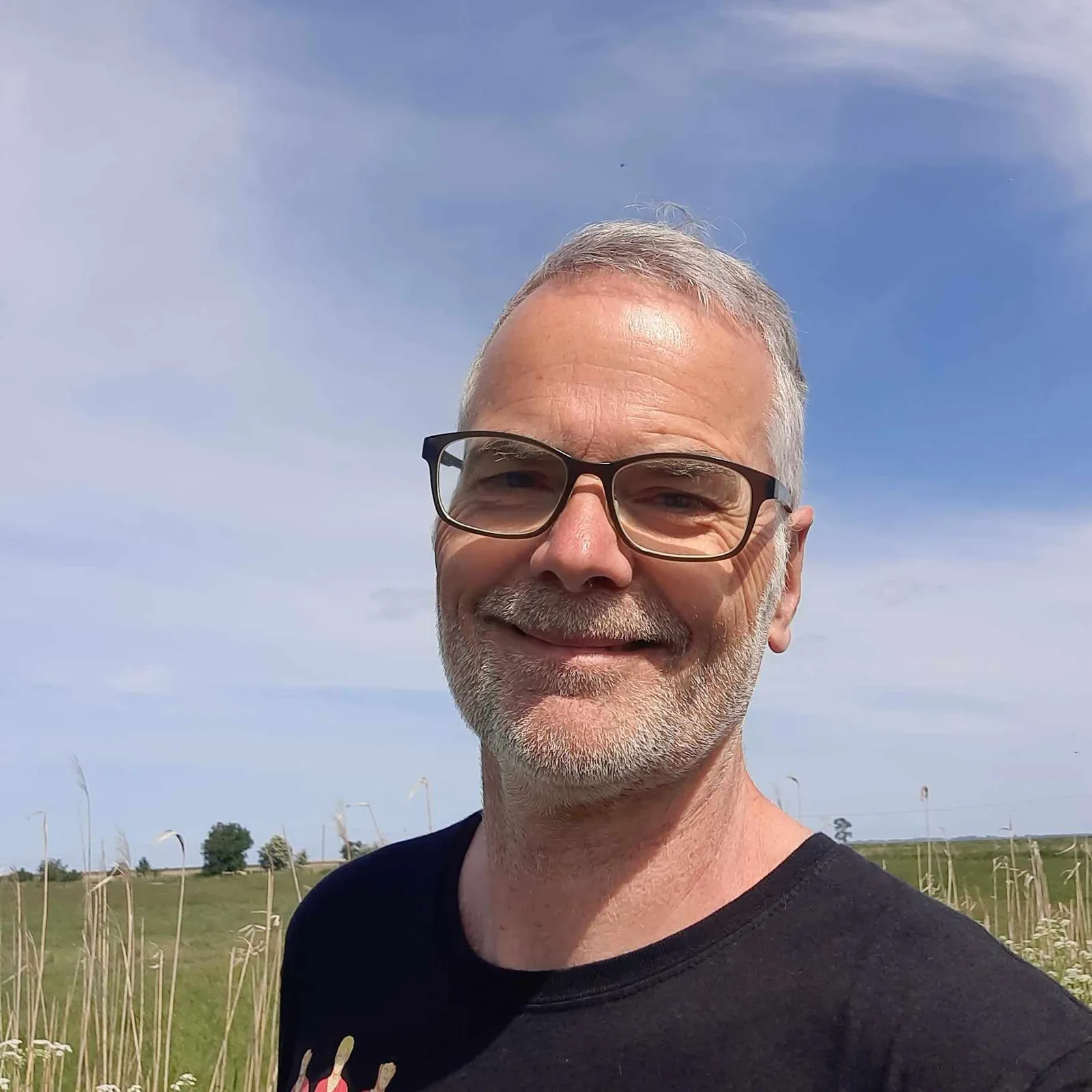 Portraitfoto Frank Willenberg mit Brille vor Naturlandschaft