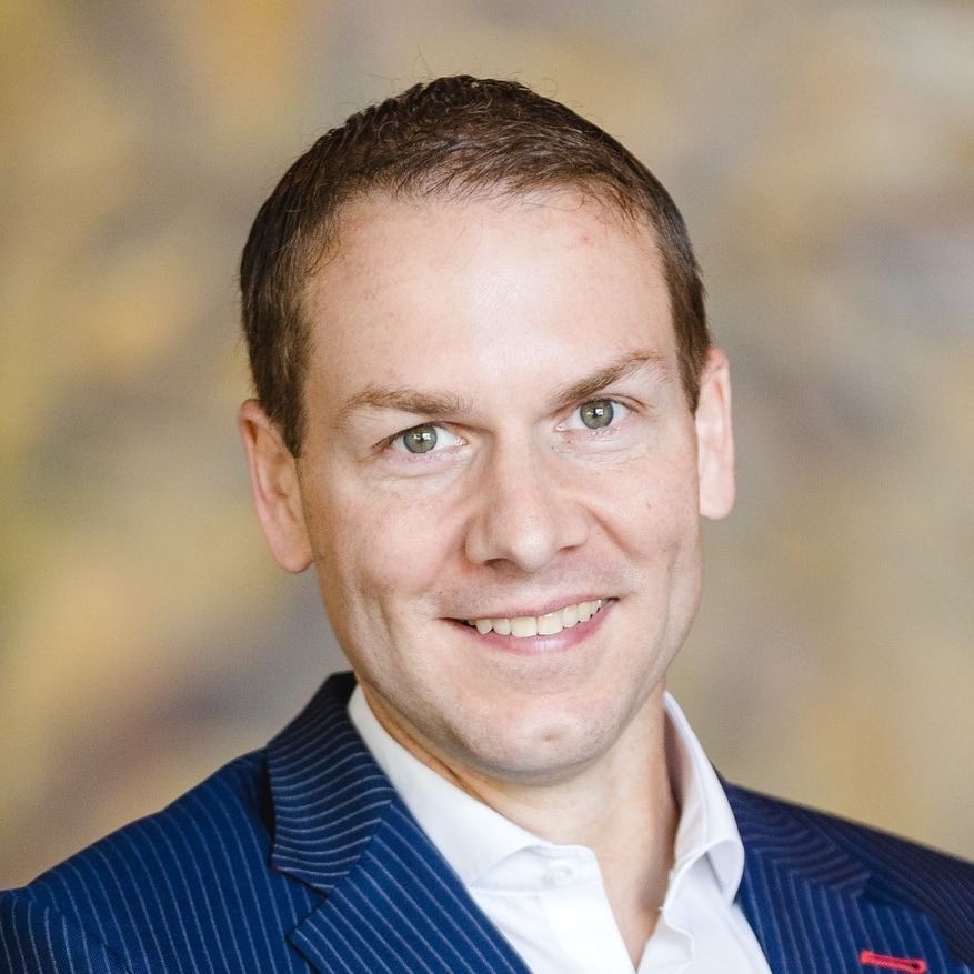Semmelroth, Porträt eines Mannes mit kurzen Haaren im dunklen Blazer mit Streifen