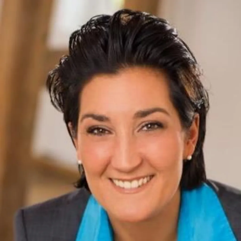 Daniela Besaid, Porträt einer Frau mit dunklem Haar im blauen Blazer
