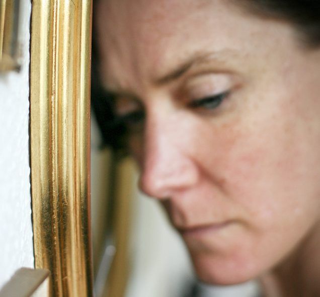Seitenprofilaufnahme einer traurigen Frau neben goldenem Bilderrahmen