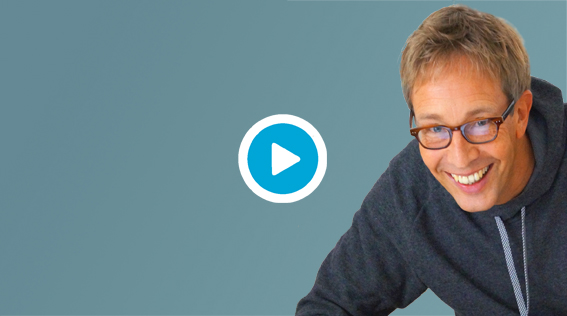 Lachender Mann mit Brille und dunklem Kapuzensweatshirt vor türkisem Hintergrund mit Play-Button