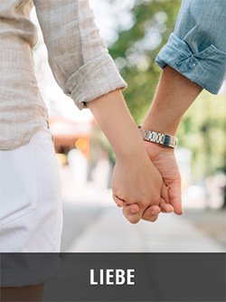 Zwei Personen halten sich an den Händen, Nahaufnahme mit Armbändern