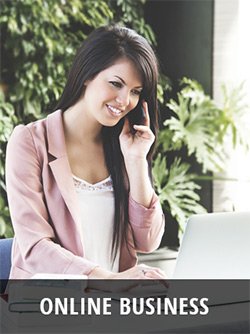 Frau am Laptop im grünen Büroumfeld, telefonierend
