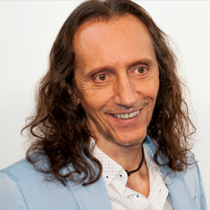 Portrait eines Mannes mit langen Haaren, hellblauem Hemd und weißem Kragen