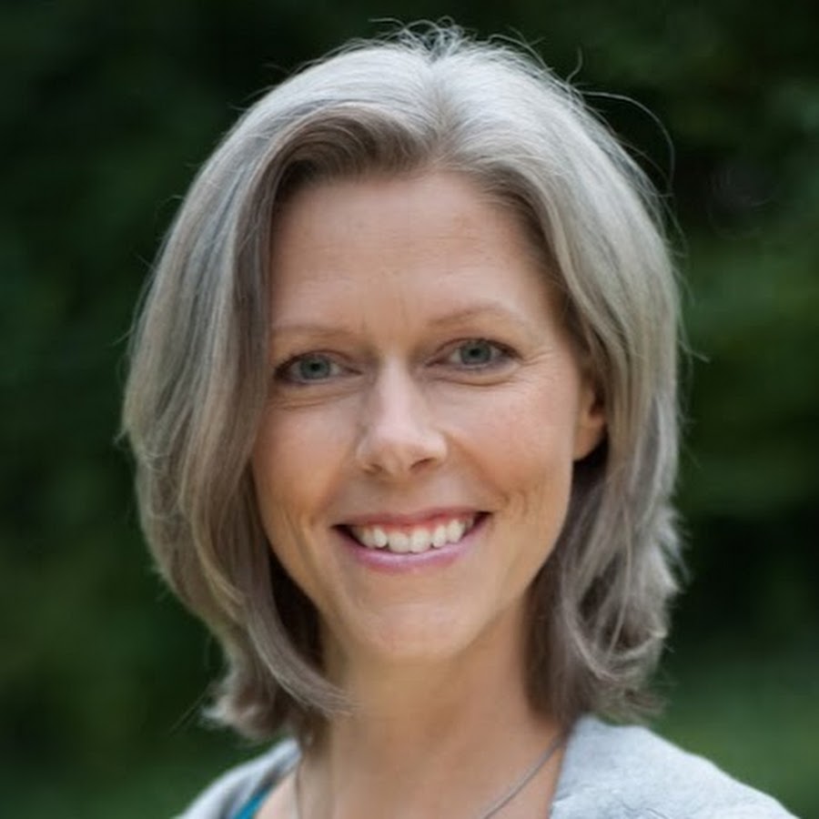 Porträtfoto einer Frau mit grauem Haar, lächelnd vor grünem Hintergrund